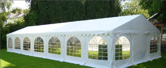 White party tent with arched windows on a grassy area