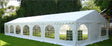 White party tent with arched windows on a grassy area