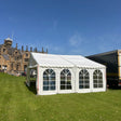White marquee tent on grass with a clear blue sky