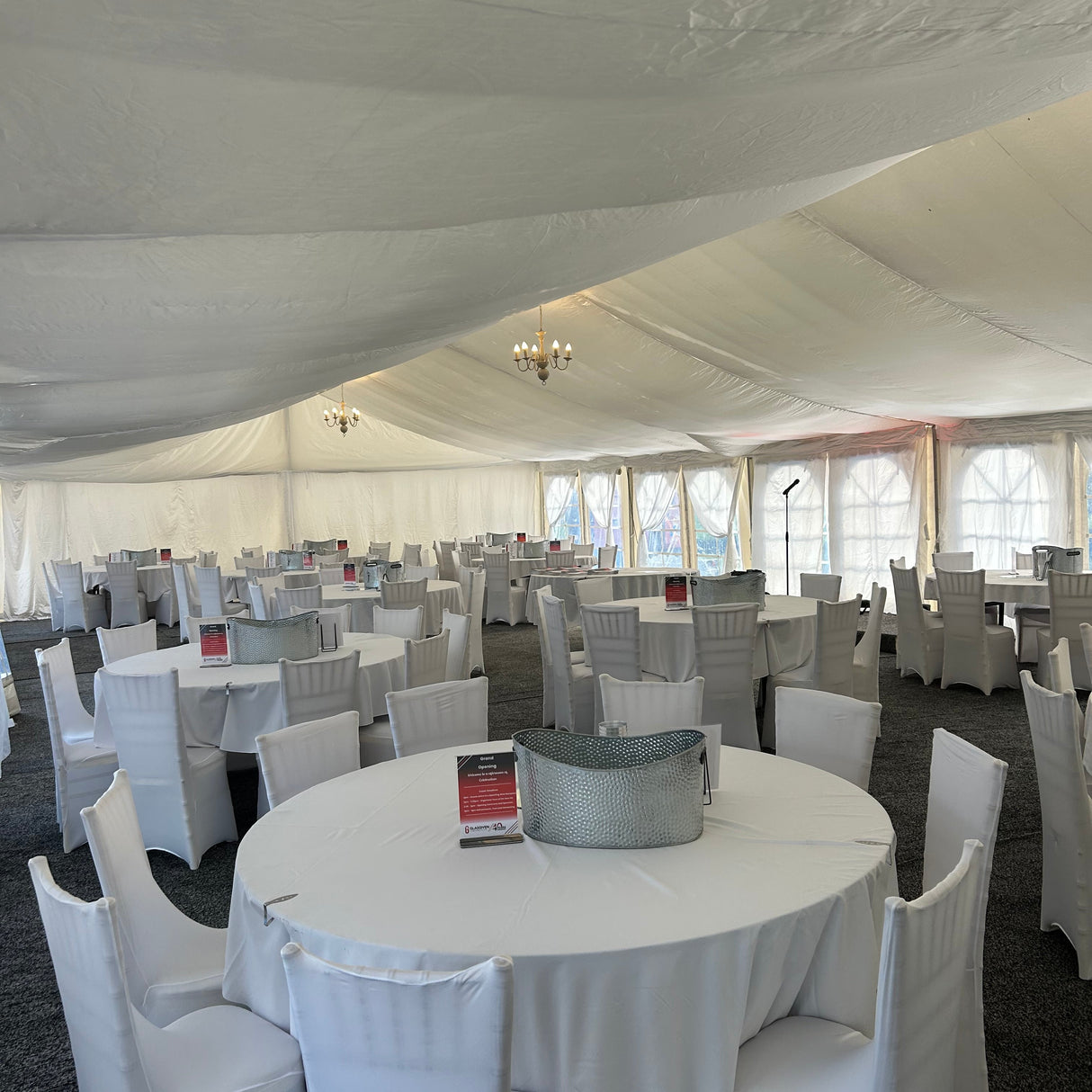 White round tables and chairs set up in an indoor event space.